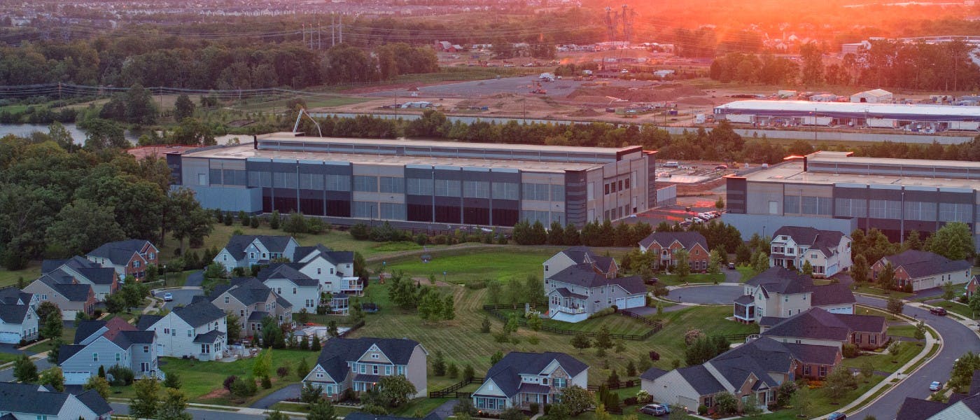 A datacenter built right next to a neighborhood, image attributed to Jahi Chikwendiu.